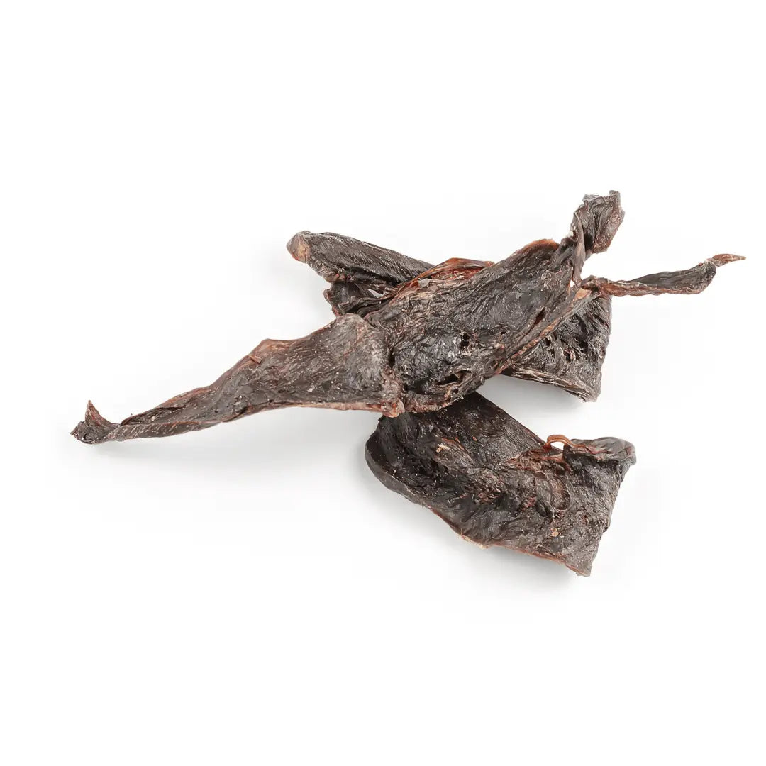Three pieces of Dog Treats Buffalo Heart - 60 gms from www.barfindia.com are arranged on a white background. Their rough, uneven texture and curled edges make them ideal natural treats for your dog.