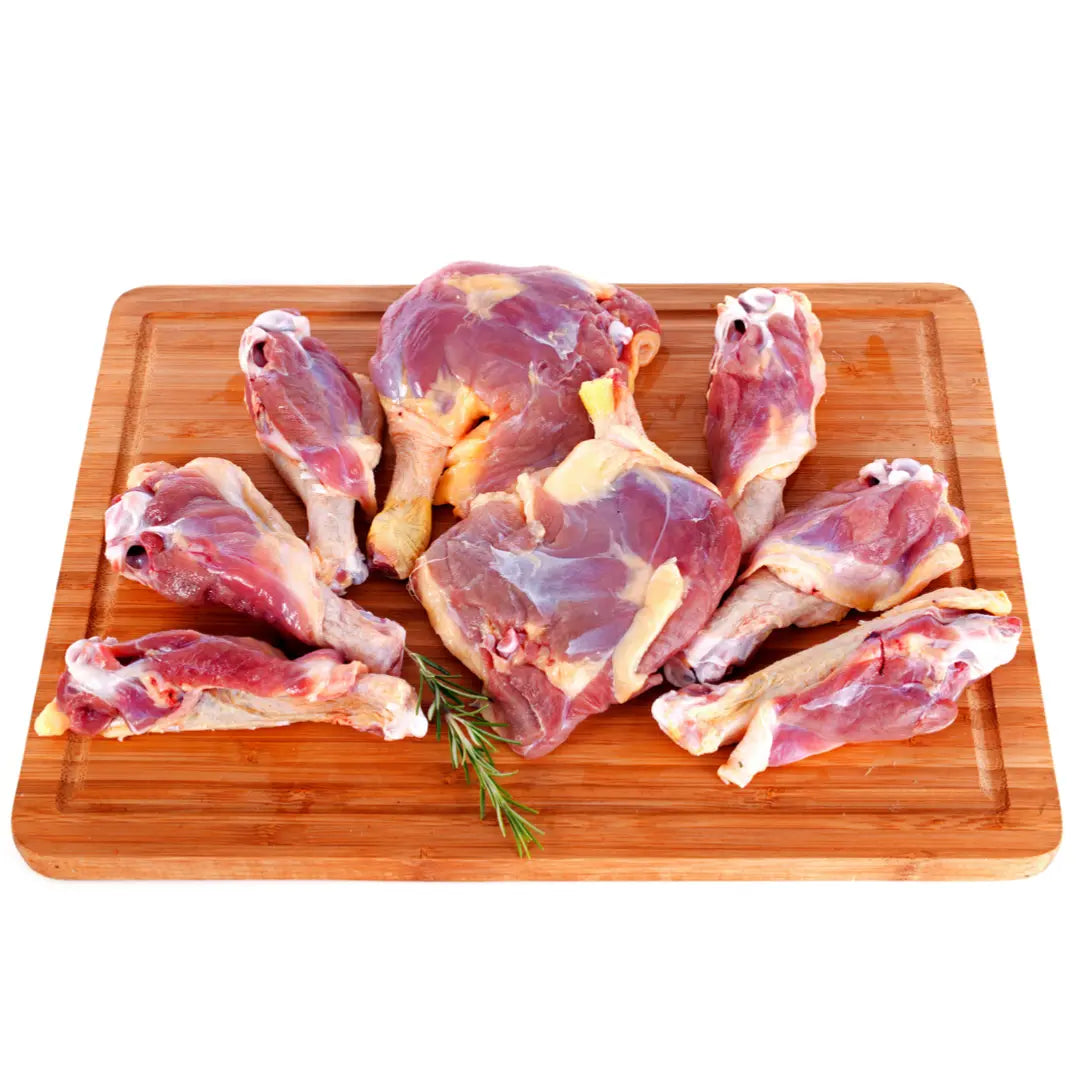 Raw Dog Food - Duck Recipe (4kgs) by www.barfindia.com shown as fresh duck pieces on a wooden board with rosemary, emphasizing the quality of this single-protein raw dog food, isolated on a white background.