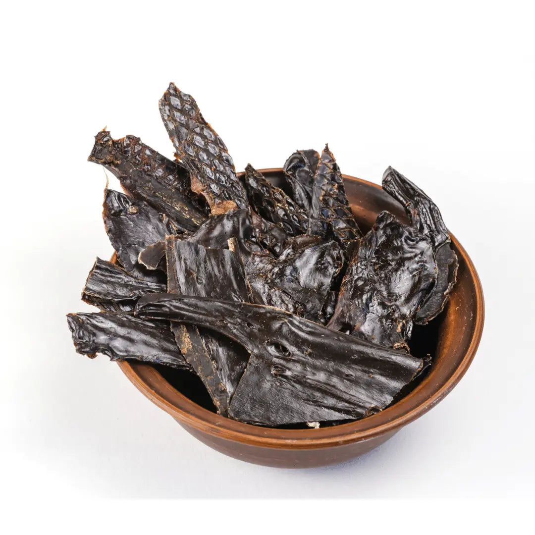 A brown bowl with pieces of Dog Treats - Dehydrated Pork Liver (100gms) by www.barfindia.com sits against a plain white background.